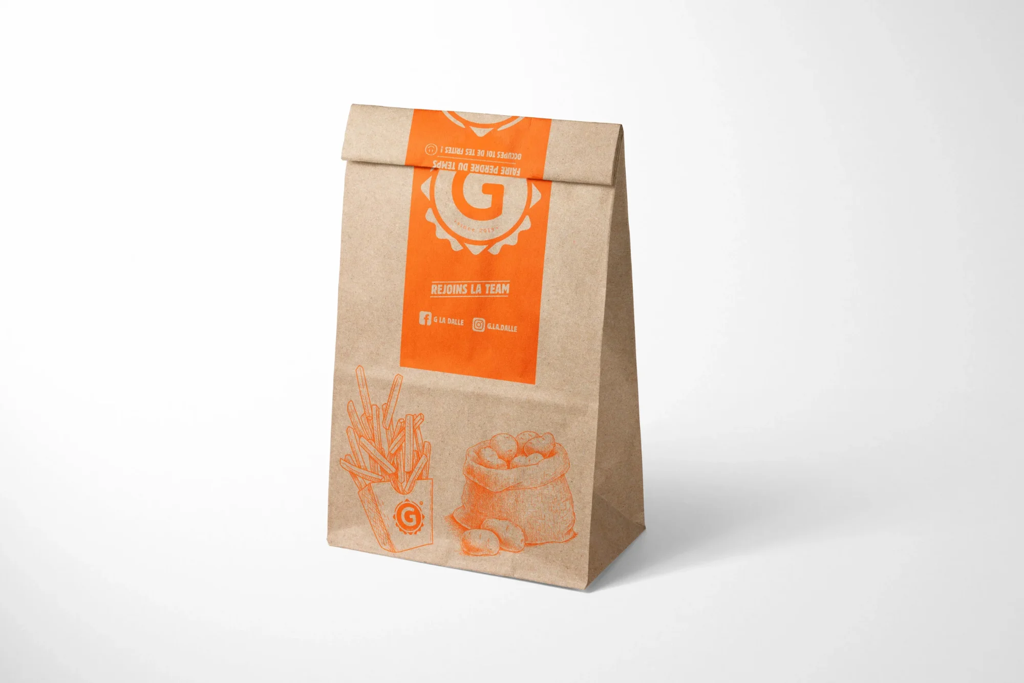 Sac d'emballage en papier kraft de la marque G La Dalle avec illustrations de frites et de sac de pommes de terre, vue sous angle.