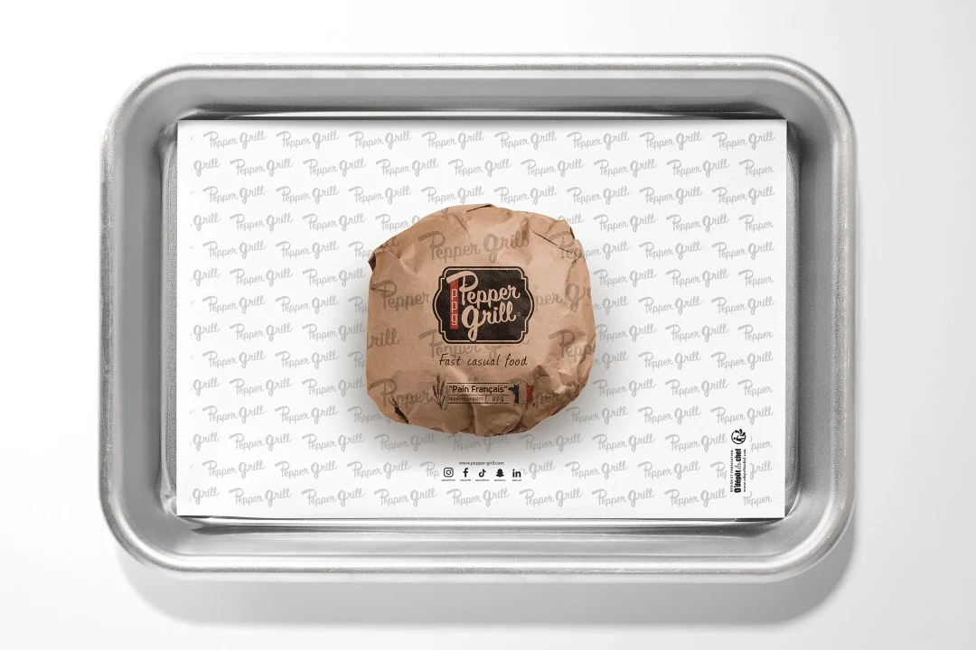 Hamburger wrapped in custom printed greaseproof paper inside food packaging box